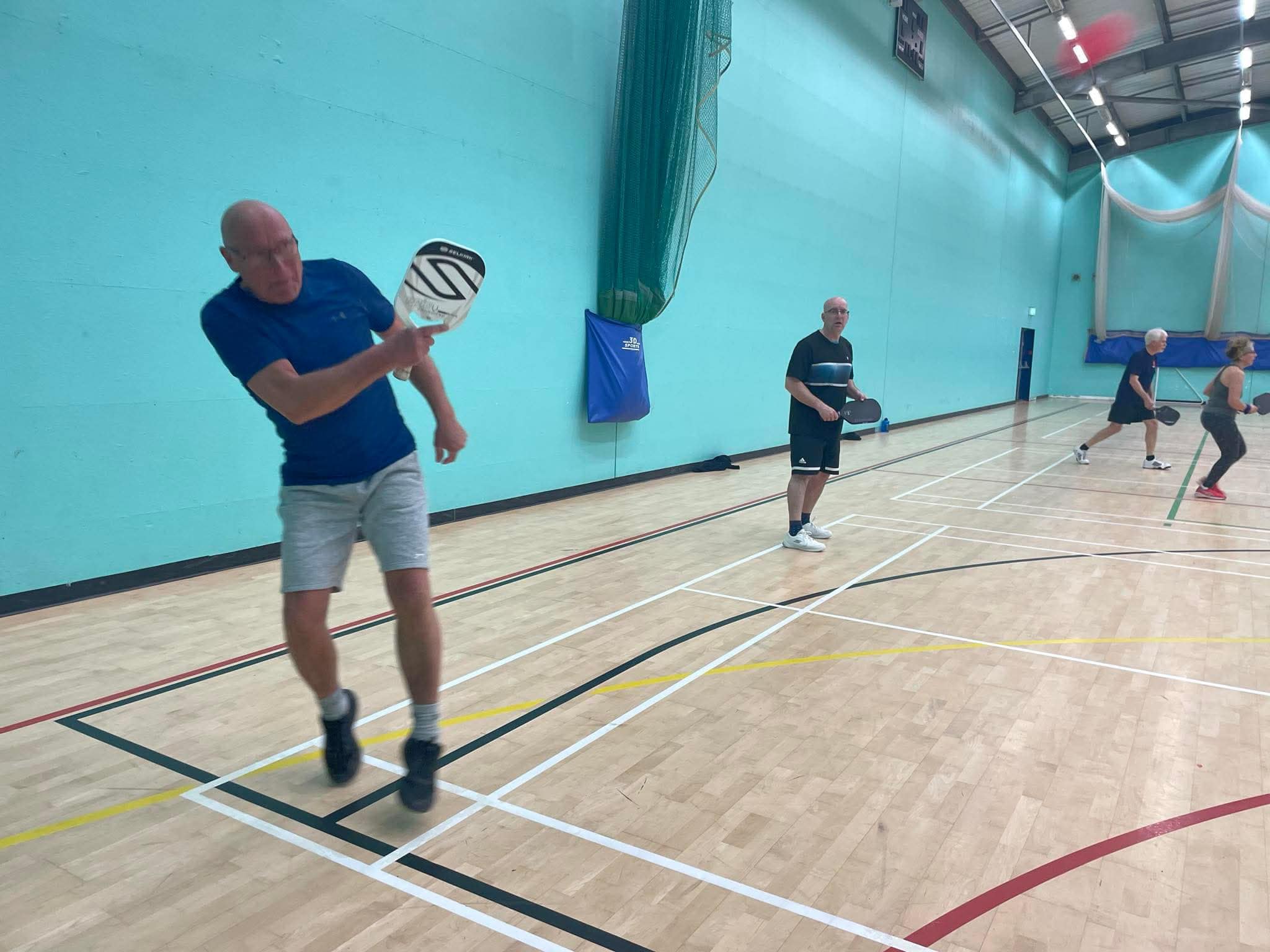 A First & Last member mid-swing on court at GO! St Just.