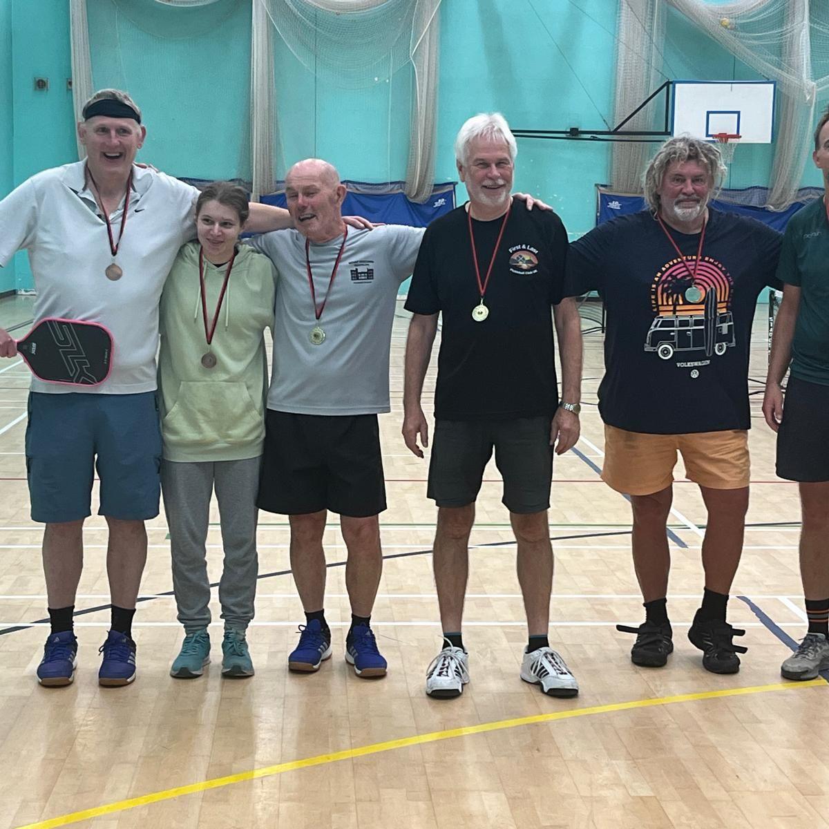 Six members of the club wearing medals after a club tournament.